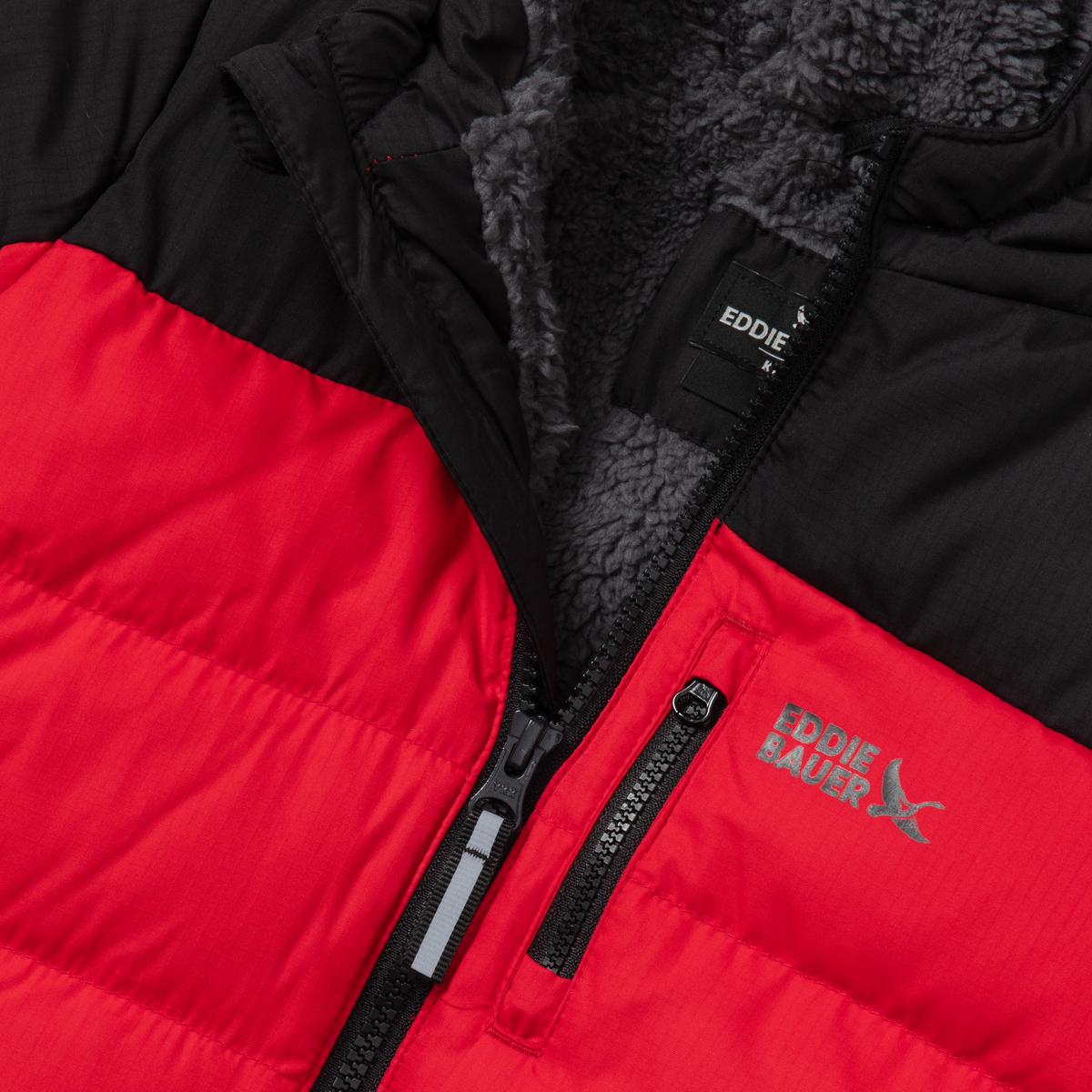 Black and red down jacket with gray fleece lining, front zipper, and brand label visible.