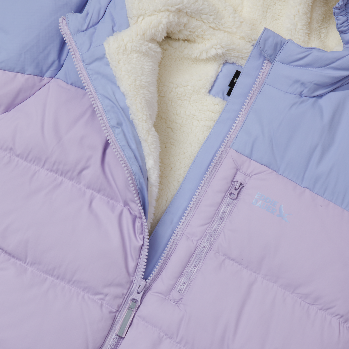 Quilted down jacket in lavender and periwinkle with cream fleece lining and front zipper detail.