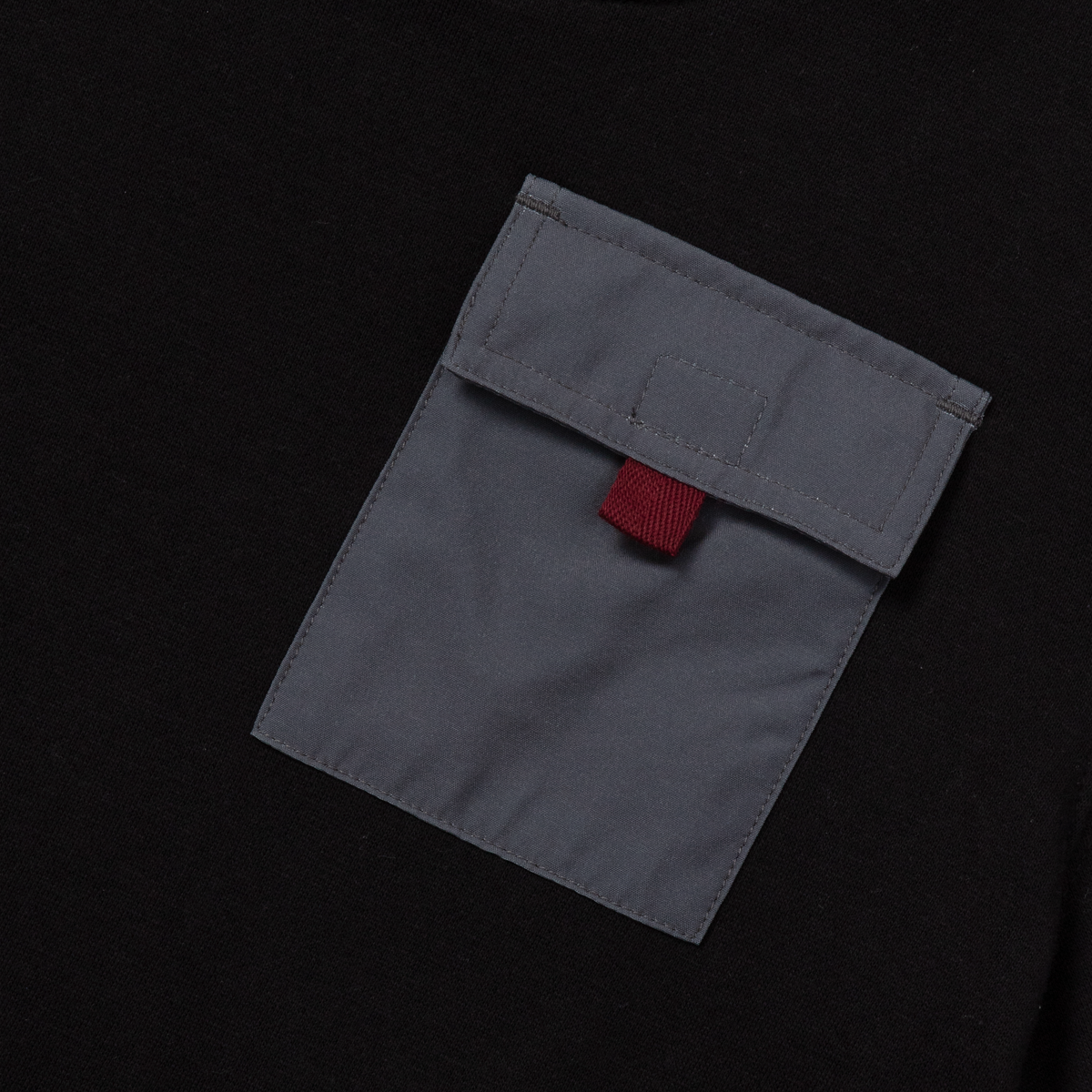 Gray fleece pocket with red label detail on black background.