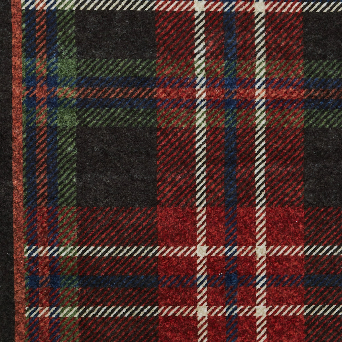 Close-up of a plaid fabric with red, green, and black colors.