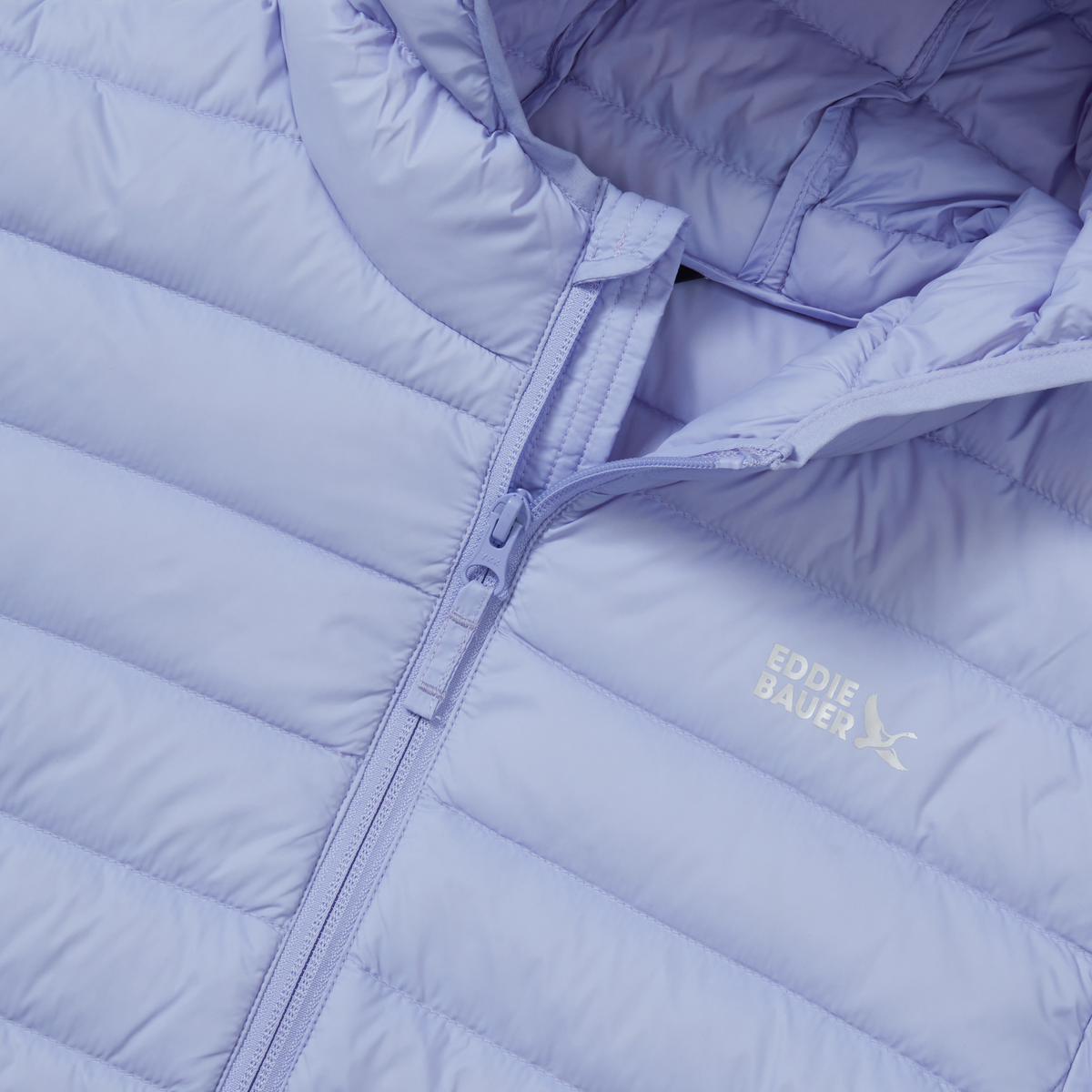 Lavender quilted down jacket with front zip closure and hood, showing diagonal stitching pattern and brand logo.
