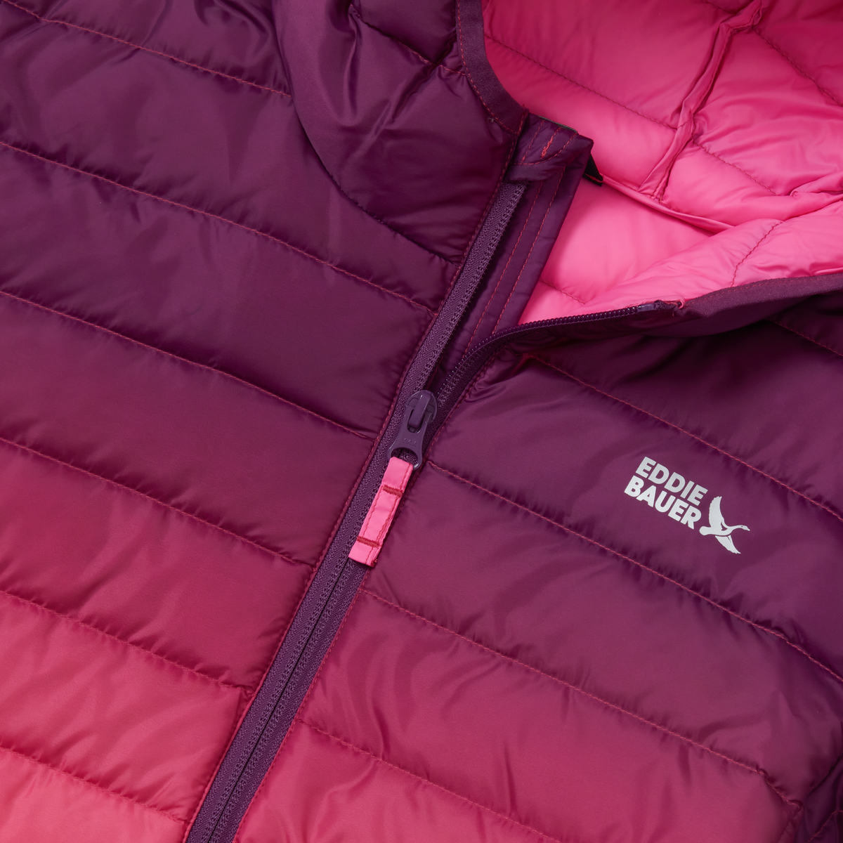 Purple and pink quilted down jacket with full-length zipper and Eddie Bauer logo visible on chest.