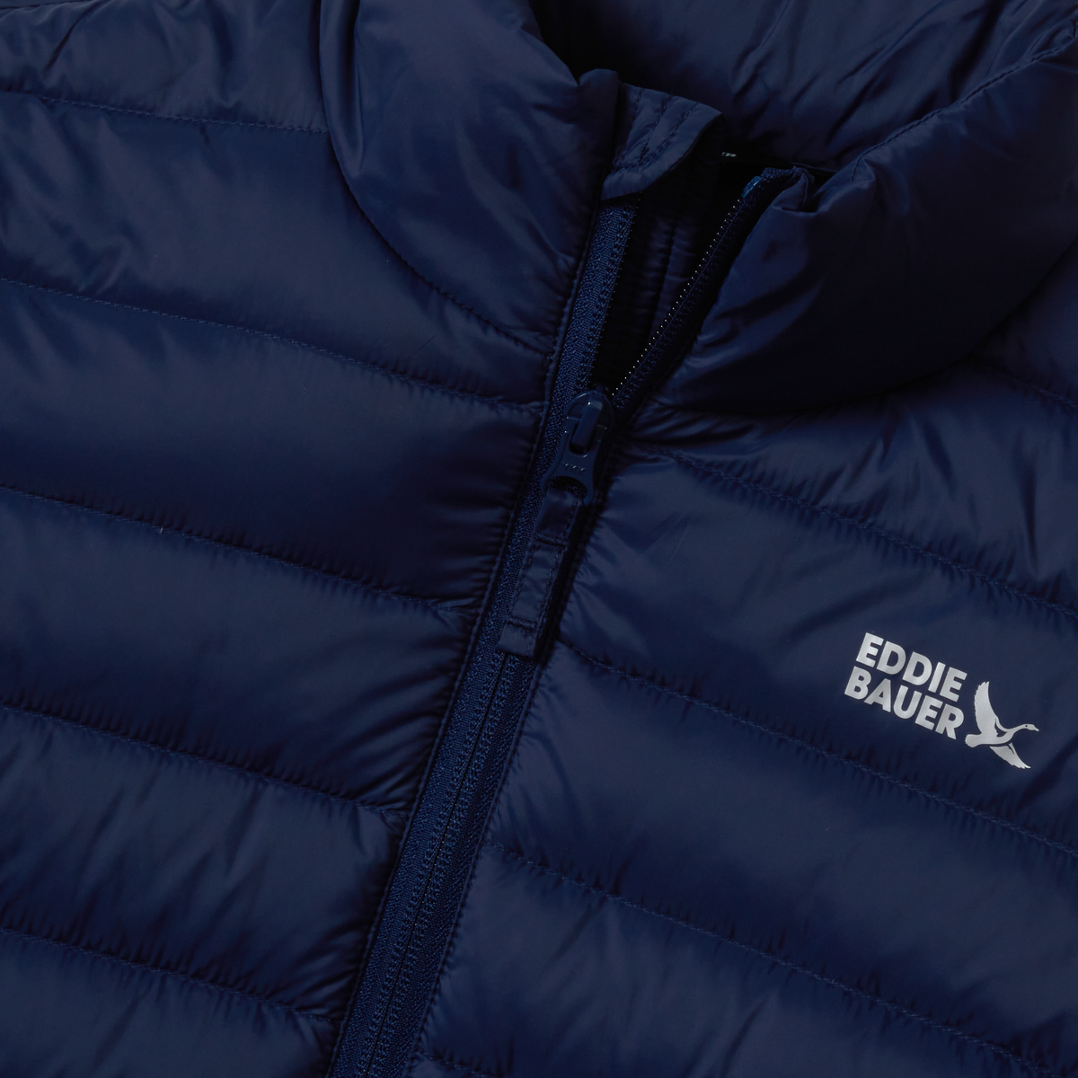 Navy blue quilted down jacket with front zipper and Eddie Bauer logo on chest.